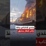 جندي أوكراني يساعد في إنقاذ ركاب قطار محترق بعد هجوم روسي